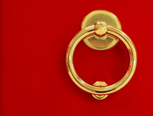 The round door handle on a red background.