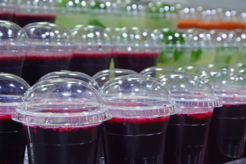 Fresh pomegranate juice and mojito in plastic glasses on the counter. A cool drink is sold at a market in Jerusalem, Israel.