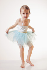 Obraz premium Cute little child girl in light blue dress plays in the ballet.