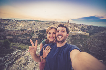 happy couple travelling in south of italy, take selfie in Matera, Basilicata, unesco site, capital...