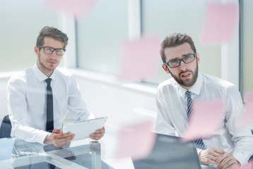 two thoughtful employees sitting at a Desk.