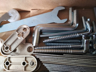 Ironmongery silver bronze iron stainless steel wrench tapping screw repair cardboard background...