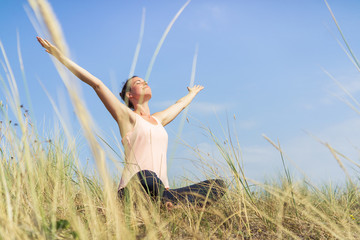Young Woman doing Yoga on the beach