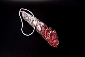 Finely chopped sausage on black background close-up