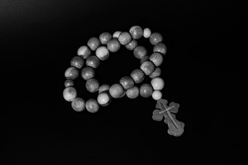 Rosary with a cross on a black background