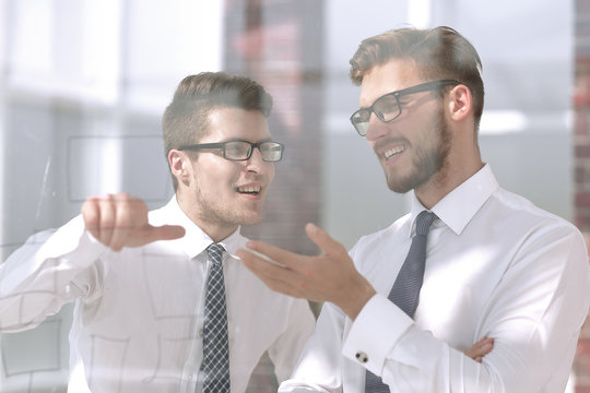 Close Up.two Employees Talking Standing In The Office