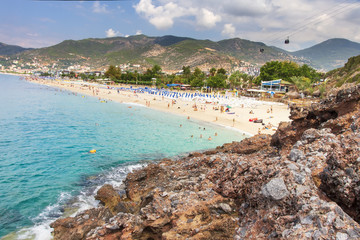 Turquoise water in sea on Cleopatra beach in Alanya, Turkey. Paradise lagoon on turkish resort in Alanya. Rest on mediterranean sea. Sandy tropical beach with rocks on coastline.