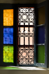 Open window with colored glass and arabic grill in Marrakesh