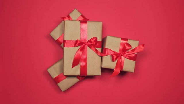 Hands grabbing gift boxes on red flat lay