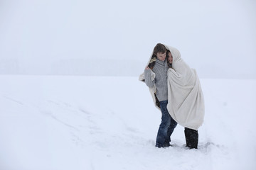 Fototapeta na wymiar pair of lovers on a date winter afternoon in a snow blizzard