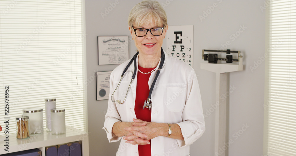 Wall mural Senior woman doctor standing looking at camera