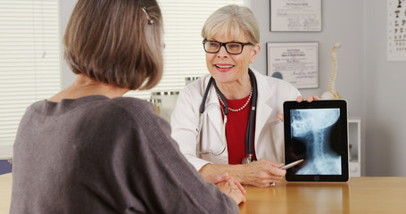 Senior doctor tablet talking x-ray