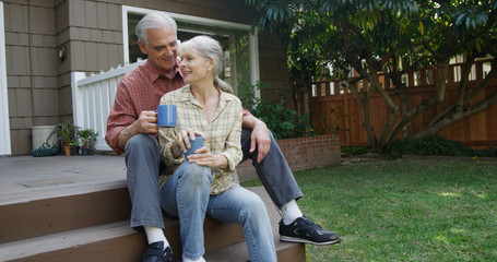 Happy senior couple enjoying a morning cup of coffee outdoors