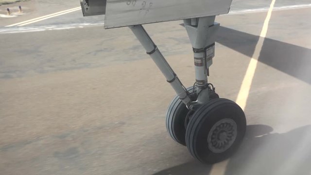 Wheels of aircraft leaving ground at take off at airport runway.