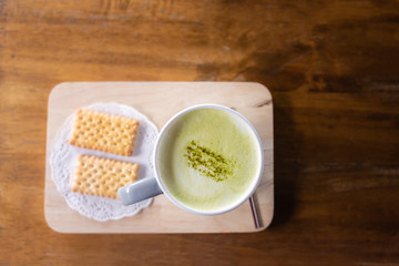 Cup of Green tea on dark wooden background, top view