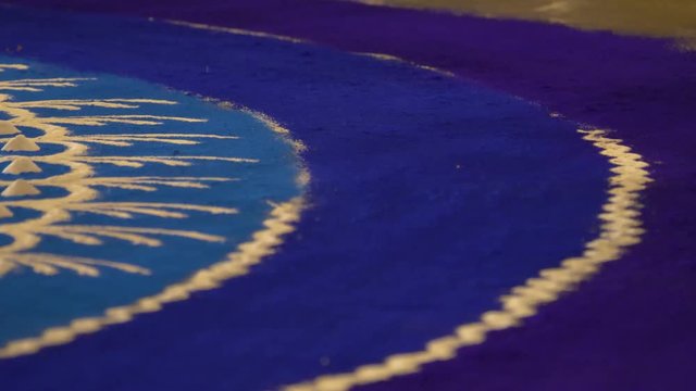 Rangoli with coloured powder being created by Rangoli artist on occasion of Hindu festival, Mumbai, Maharashtra, India.