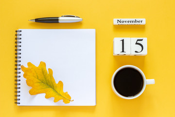 Autumn composition. Wooden calendar November 15 cup of coffee, empty open notepad with pen and...