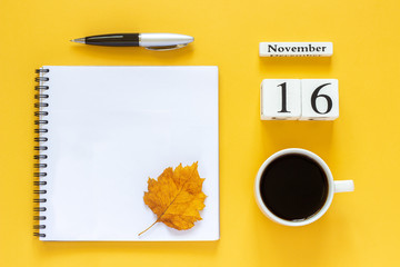 Autumn composition. Wooden calendar November 16 cup of coffee, empty open notepad with pen and yellow oak leaf on yellow background. Top view Flat lay Mockup Concept Hello November