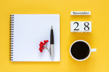 Autumn composition. Wooden calendar November 28 cup of coffee, empty open notepad with pen and yellow oak leaf on yellow background. Top view Flat lay Mockup Concept Hello November