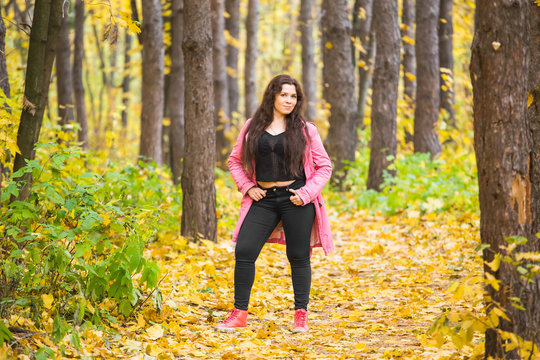 Autumn, Nature And People Concept - Portrait Of Plus Size Woman In Pink Jacket In Park