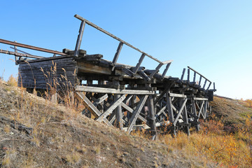 Fototapeta premium Abandoned railway bridge on a Sunny autumn day in the North of Siberia