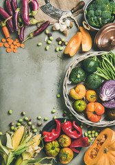 Healthy vegetarian seasonal Fall food cooking background. Flat-lay of Autumn vegetables over grey concrete background, top view, copy space, vertical composition. Vegan, alkaline diet food