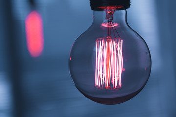 A classic Edison light bulb on dark background with space for text