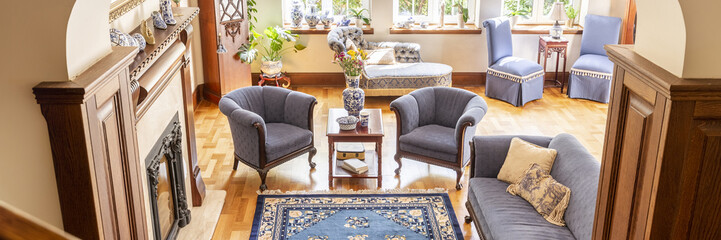 Top view of a luxurious living room interior with cobalt blue armchairs and a couch in front of a...