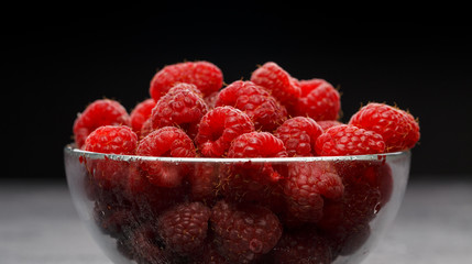 Photo of raspberries in transparent glass cup