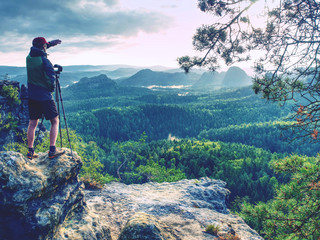 Photographer shooting stunning landscape on daybreak in nature