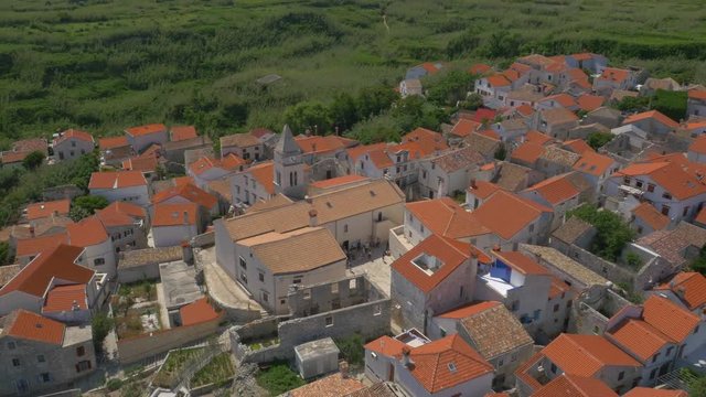 Aerial - High angle view of tourists visiting the Christian church on Susak