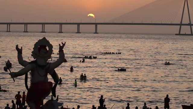 Ganesh idol carried to the sea water at the beach for immersion. Last day of the Ganesh Festival celebration in Mumbai, India.