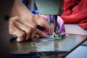 Woman's hands sewing fabric  repairs on old sewing