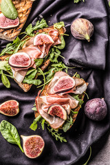 Sandwich with figs prosciutto spinach arugula and cheese dip