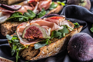 Sandwich with figs prosciutto spinach arugula and cheese dip