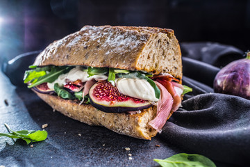 Sandwich with figs prosciutto spinach arugula and cheese dip