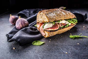 Sandwich with figs prosciutto spinach arugula and cheese dip