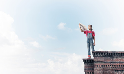 Concept of careless happy childhood with girl dreaming to become
