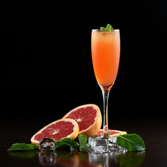 Composition of tall cocktail glass with cold summer refreshing orange juicy drink, slices of...