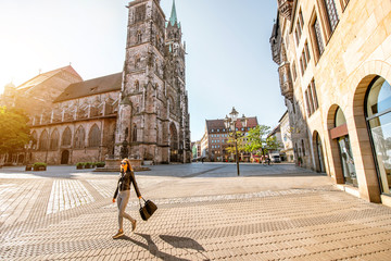 Morning view on the saint Lorenz cathedral with woman walking in the old town of Nurnberg, Germany