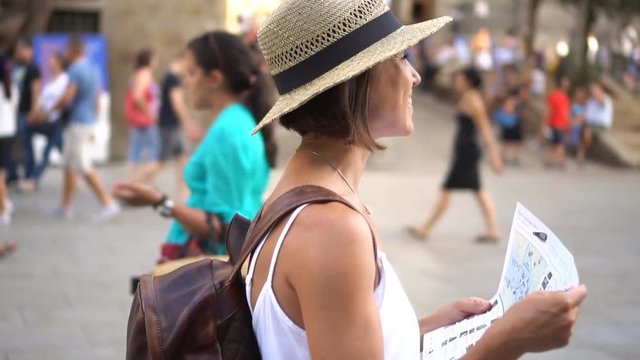 Smiling woman tourist sightseeing with map