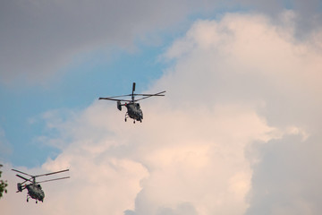 Helicopters fly away on a background of clouds