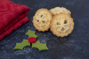 Three mince pies on a dark background with christmas decoration 