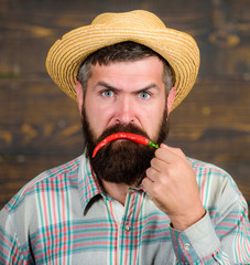 Pepper harvest concept. Bearded farmer hold chilli red pepper in hand. Farmer presenting hot chilli...