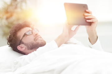 closeup.sleepy man looking at the screen of a digital tablet.