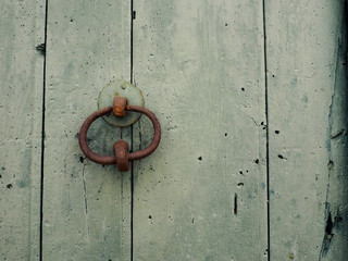 Llamador antiguo en una puerta verde de madera envejecida