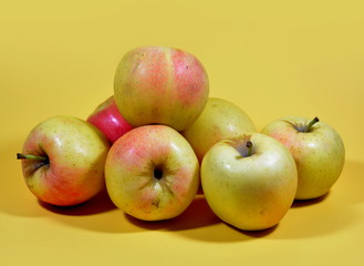 Ripe apples on yellow background