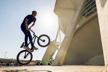 Guy with a bmx doing tricks for the city. Concept of young people doing extreme sports