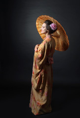 Young beautiful woman in traditional japanese kimono with umbrella.