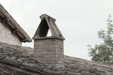 Isolated chimney on the roof of an ancient house (Marche, Italy, Europe)